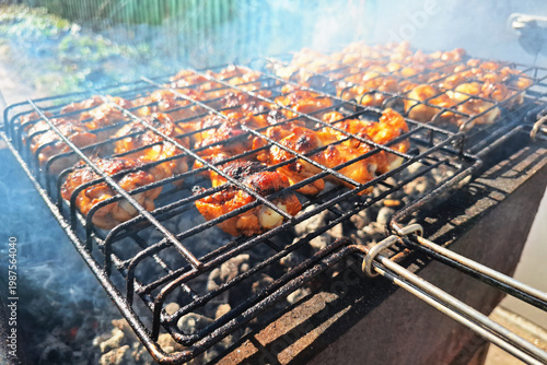 Grilled chicken pieces on barbecue