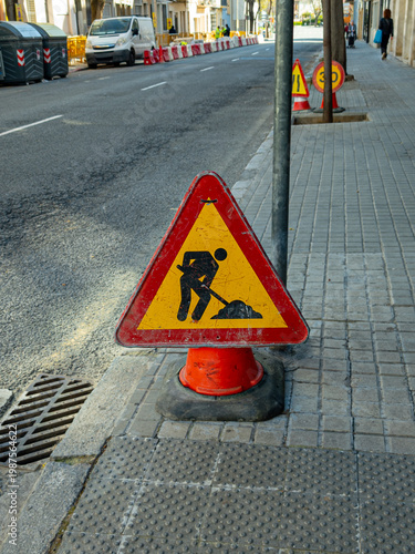 Roadwork Warning Sign on Urban Sidewalk with Construction Barriers