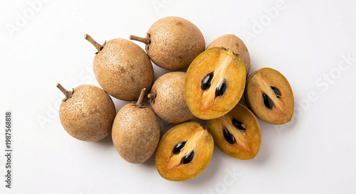 Fresh whole and halved sapodilla fruit on white background