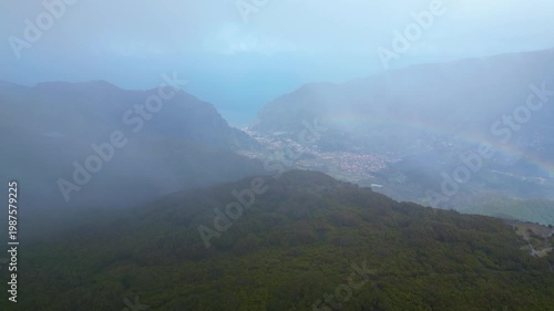 A winding road through the misty, wind-swept Paul da Serra plateau in Madeira, dotted with renewable energy turbines. An atmospheric drive.
