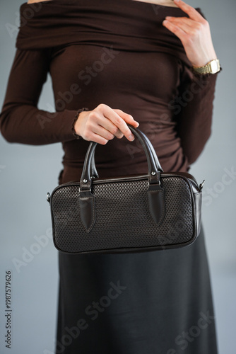 Wallpaper Mural Woman Holds Black Leather Purse Poised, Brown Fitted Top And Black Skirt, Polished Nails, Everyday Office Torontodigital.ca