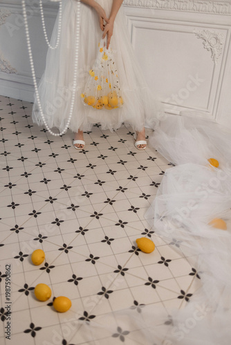 Bride In Tulle Gown Holding Lemons, Patterned Tile Floor, Scattered Citrus, Delicate Pearl Strings, Soft Natural Light, Minimalist Elegant Styling With Whimsical Bridal Mood