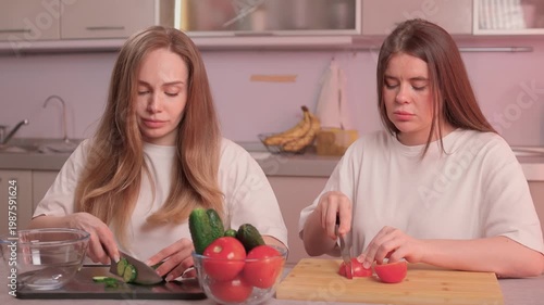 Female cooks work united to prepare and cut vegetables efficiently. Women collaboratively and diligently chop vegetables together to prepare ingredients for cooking