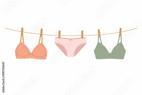 Colorful lingerie set hanging on clothesline - pink and green bras and panties