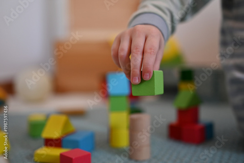 A child is playing with blocks. In this capture the child grabs a cube. 