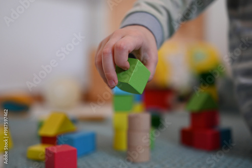 A little child grabs a block while playing with blocks