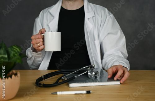 A doctor is drinking coffee during a break 