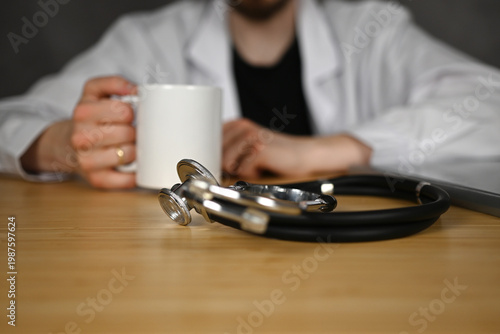 A doctor is taking a break and drinking coffee