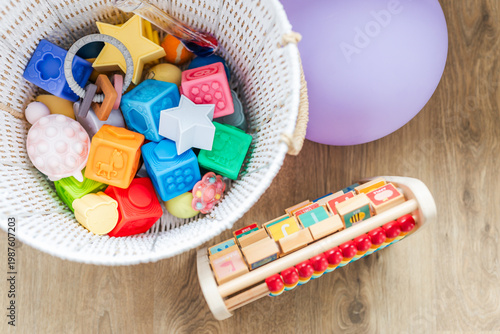 white basket with silicone baby toys abacus and balloon early learning concept