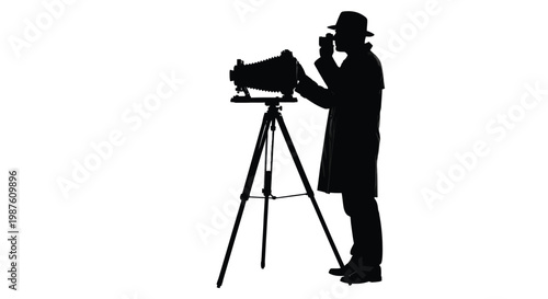 Vintage photographer operating an old camera on a tripod silhouette