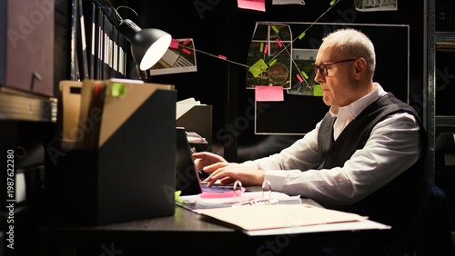 Картината върху платно Senior officer on clandestine operation, private detective working with case files to uncover new details in solving crime