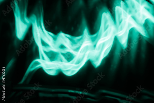 Wavy cyan light lines flowing like glowing smoke against a dark abstract background