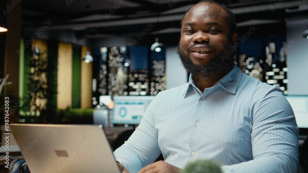 Obraz premium Portrait of black businessman does critical thinking and proofreading files before transcribing data on notebook, sitting in office at night. Documenting important ideas overtime.