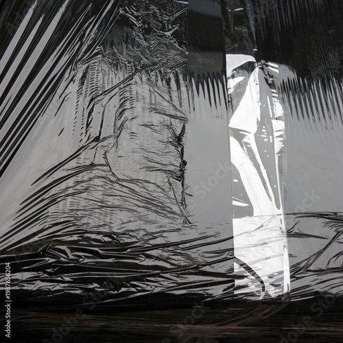 A grayscale illustration of a person wrapped in fabric standing amidst abstract lines.