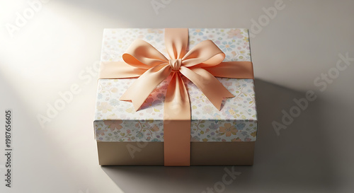 A cardboard box wrapped with decorative paper and tied with a ribbon bow on top.