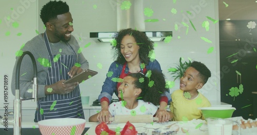 Gathering family preparing food at home kitchen island, parents in aprons, tablet and rolling pin