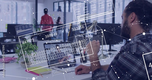 Working bearded man in plaid shirt typing on laptop and keyboard in open-plan office, copy space