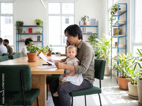 Father and baby at workplace reading documents