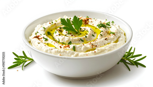 Creamy baba ghanoush dip in a white bowl drizzled with olive oil and garnished with fresh parsley and paprika presented on a white surface