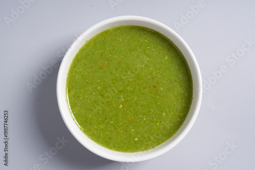 Φωτογραφία A vibrant green Thai seafood dipping sauce made from fresh chil, lime, and garlic, served in a white bowl isolated
on white background
