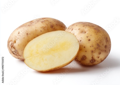 Whole and halved beige-skinned tubers with light yellow flesh, against white