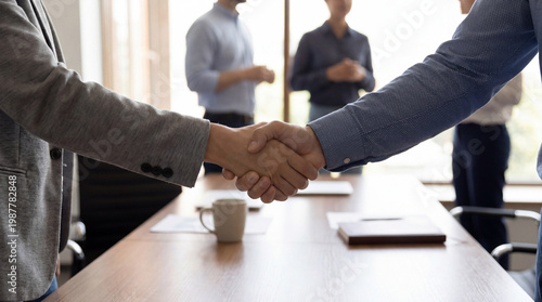 Business partners shaking hands to seal a successful deal, symbolizing agreement and trust in a professional office.