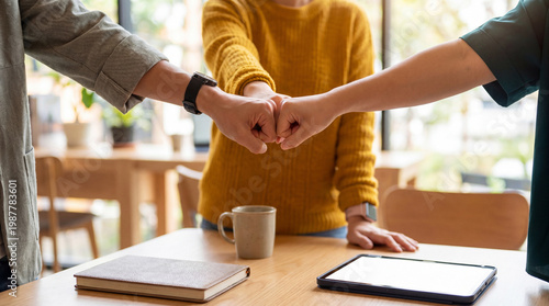 Foto Three diverse business colleagues celebrating success with a fist bump, symbolizing teamwork and strong partnership