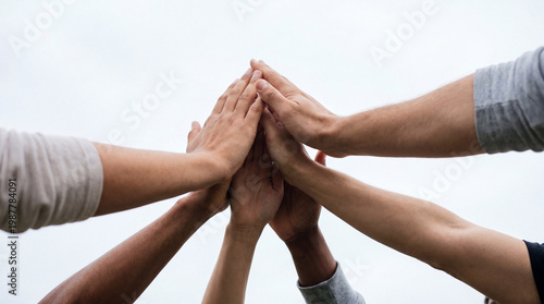 Fotografie Diverse group of people showing unity and teamwork with hands stacked in a collective high-five gesture