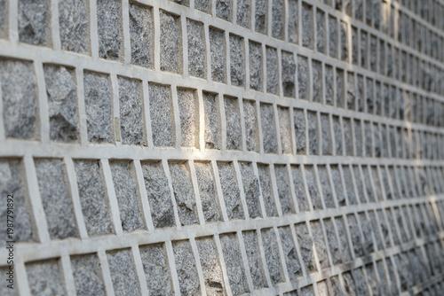 close-up of a textured stone wall with a geometric grid pattern, captured at an angle for depth, soft light creates subtle highlights and shadows, South Korea