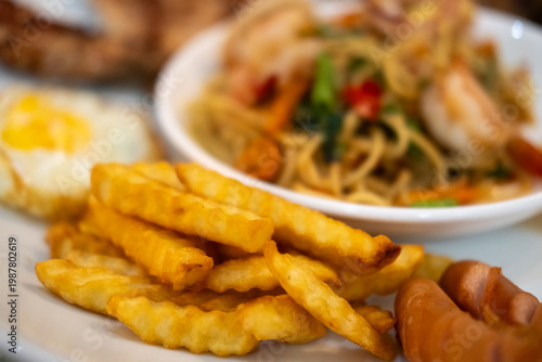 Spicy seafood spaghetti served on white plate, with french fries
