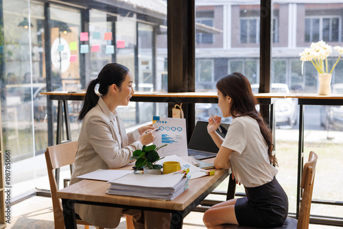 Business women discussing financial data in modern office