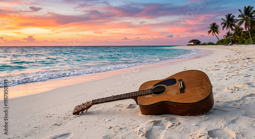 An acoustic guitar rests on a sandy beach at sunset with gentle waves meeting the shore. 