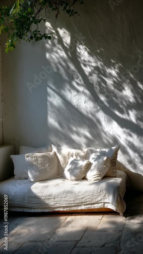 Sunlight shadow on sofa with pillow against white wall, cozy interior minimal living room feel, leaf shadow natural light, rustic patio decor