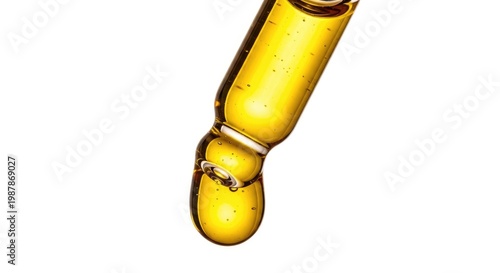 Close-up of golden liquid dripping from a dropper, representing serum or oil