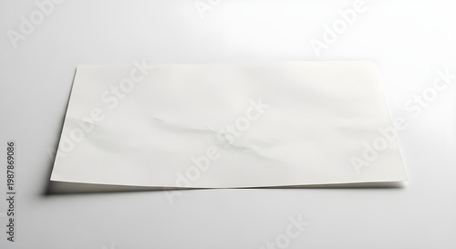 White paper sheet with a folded corner on a white surface