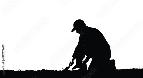 Silhouette of a gardener tending to plants against a bright background