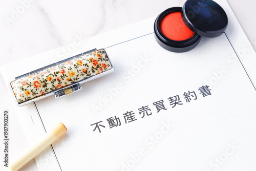 不動産を売買する契約の際に交わす不動産売買契約書と印鑑、朱肉で、不動産の売買契約のイメージ
