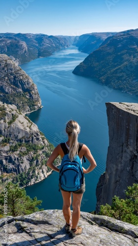 Woman hiking looking at lysefjord from preikestolen cliff