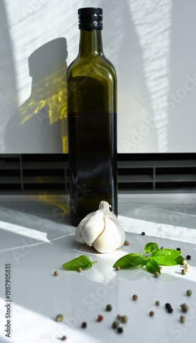 Olive oil bottle and fresh ingredients on a bright kitchen surface. Perfect for healthy organic recipes, Mediterranean cuisine, and culinary blogs.
