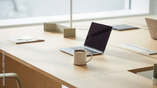 modern office desk with laptop computer and coffee mug on wooden table in bright room