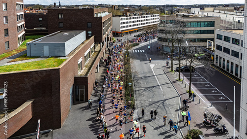 Aerial drone view of people running half marathon Venloop race in city, crowd runners on road racing sport competition, top-down view of athletes and spectators, Venlo, the Netherlands