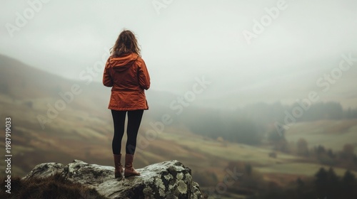 Woman contemplating misty landscape