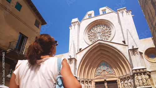 Woman tourist admiring Tarragona Cathedral Gothic architecture