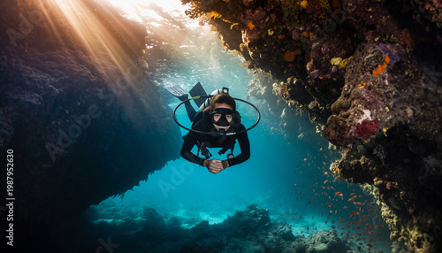 A person scuba diving in an underwater cave with coral formations.