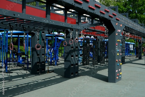 A girl is completing a suspended obstacle course at a street workout area. OCR (Obstacle Course Racing)
