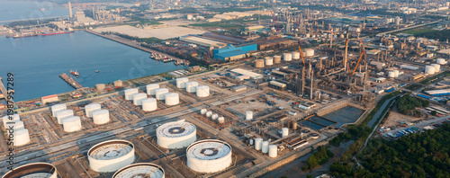 Aerial view of oil refinery, storage tanks, and adjacent port, showcasing energy infrastructure, petroleum processing, and industrial landscape.