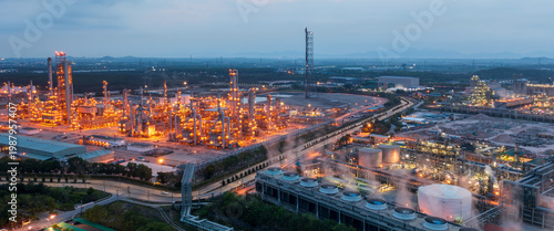Aerial view of adjacent power plants and oil refineries, showcasing energy infrastructure, petroleum processing, and industrial landscape.