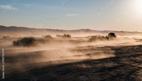 Dusty landscape with distant mountains and a hazy sky.
