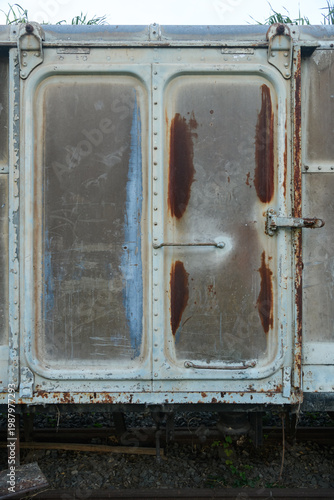 Old weathered train bogy cargo container with rust and scratches, showing aged metal textures and industrial details, perfect for concepts of history, transportation, and decay.