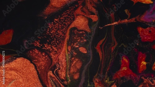 Copper orange and liquid black paint are mixed. Dark abstract background. Fluid art acrylic pouring macro texture